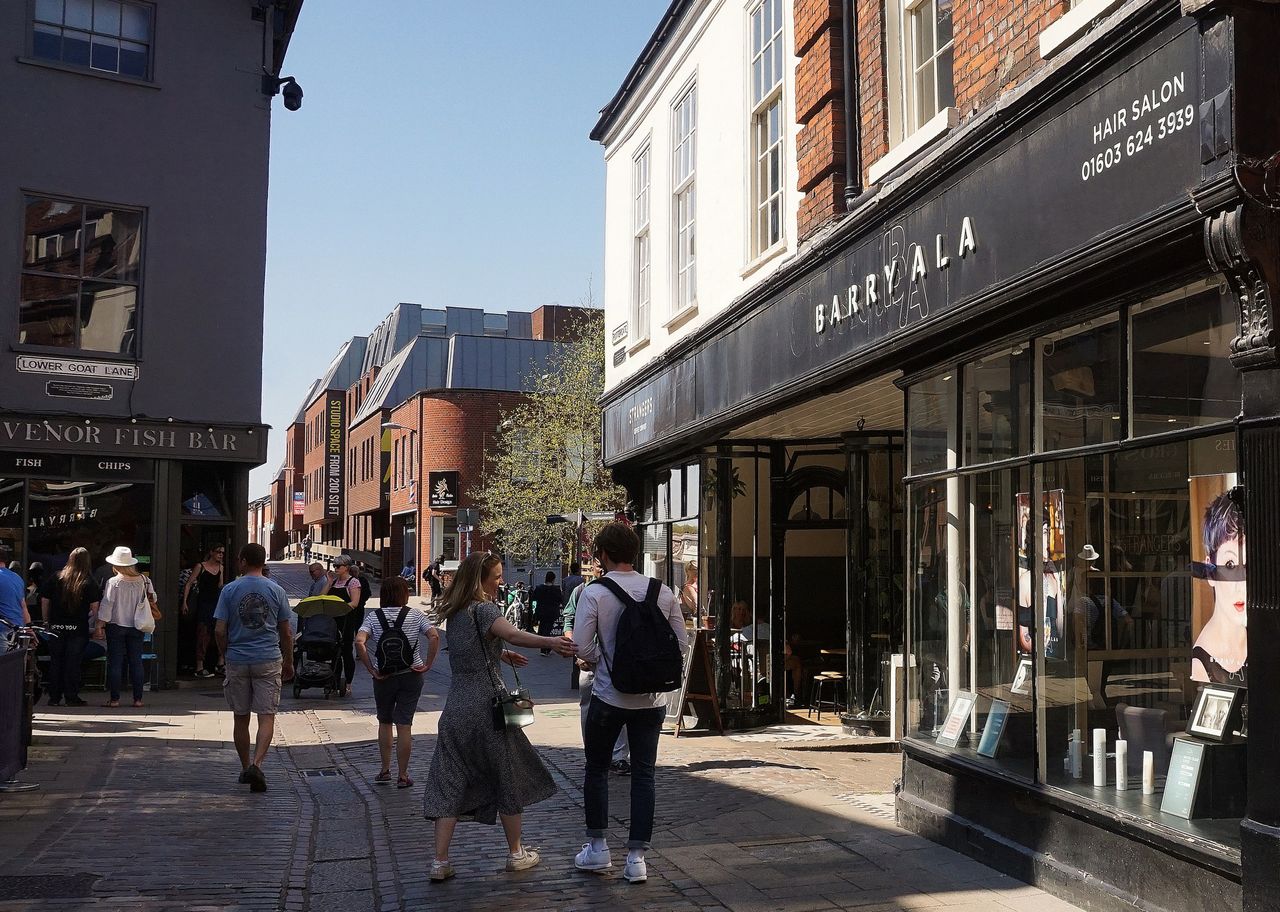 Bustling street scene with pedestrians, shops, and vibrant urban life.